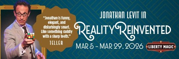 A man in a suit holds a Rubik's Cube against a geometric patterned background. Text: "Jonathan Levit in Reality Reinvented." Dates: March 5-29, 2026.